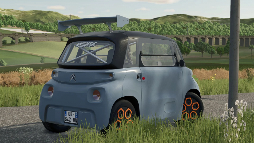 Citroën Ami mod in Farming Simulator 25, parked on a rural road with scenic hills and a bridge in the background.