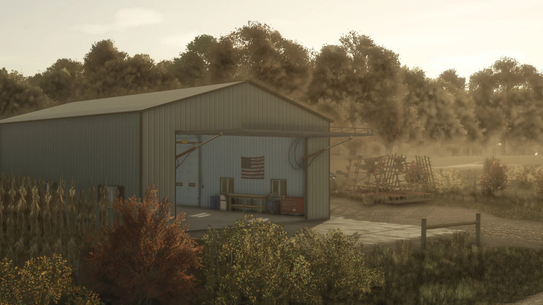 FS25 Small Heated Shop mod showing a metal barn with an American flag and farming equipment outside. Perfect addition for Farming Simulator 25.