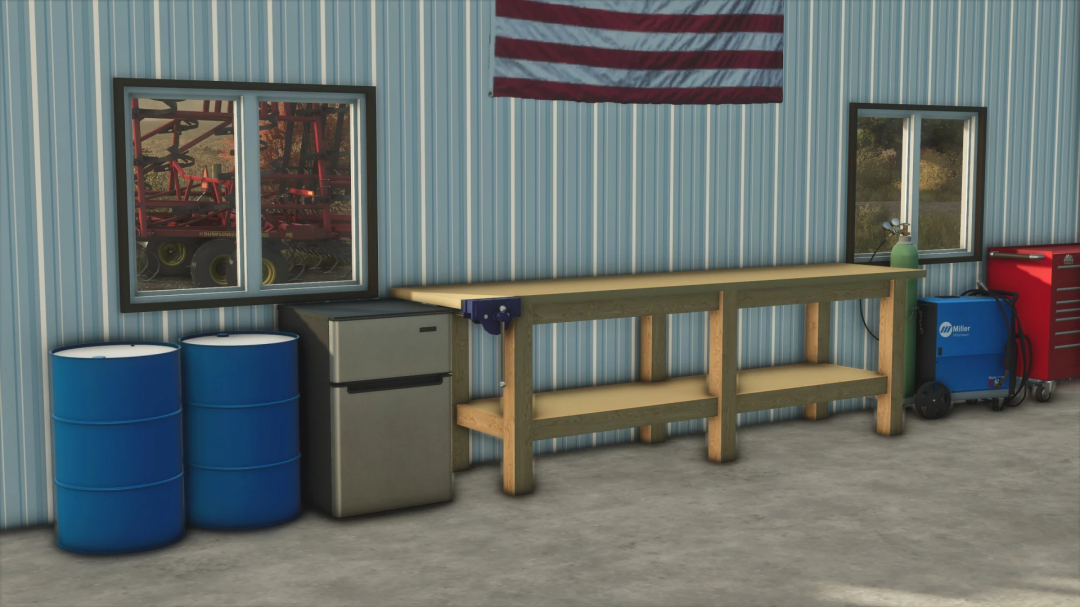 Interior of FS25 Small Heated Shop mod with tools, barrels, and an American flag. Ideal for FS25 mods fans.