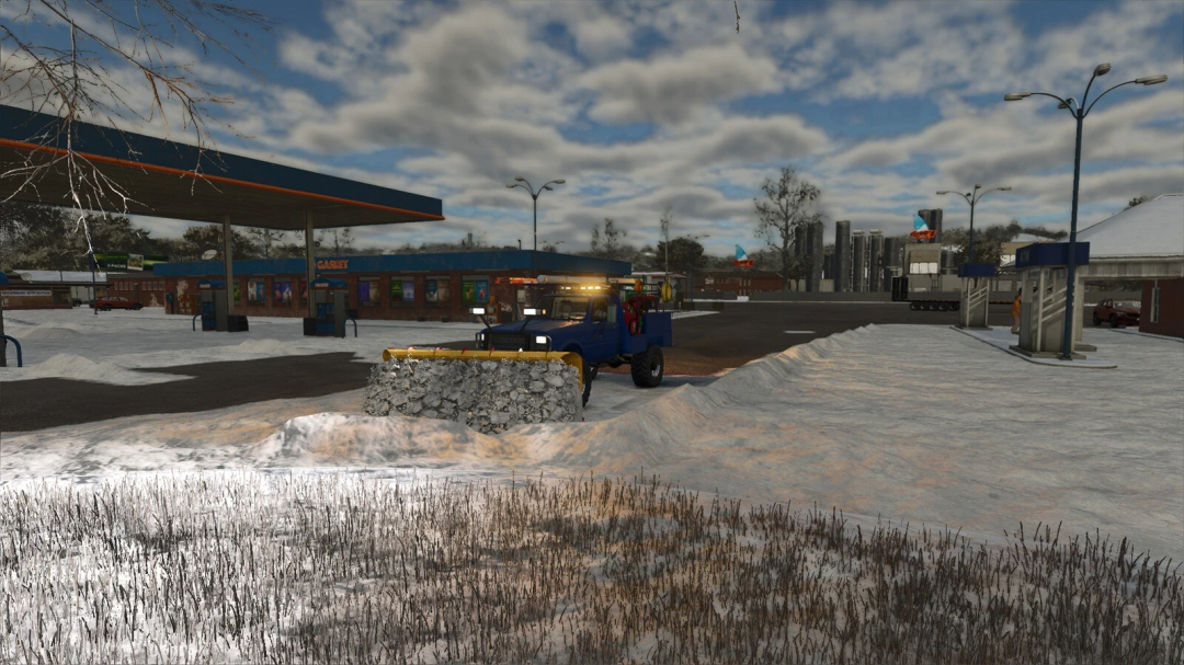 FS25 mod Flatbed Service Truck v1.0.0.0 clearing snow near a gas station in a snowy landscape.