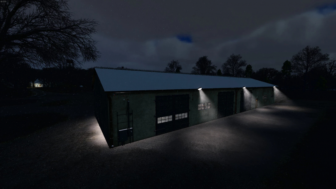 Night view of a garage with workshop in FS25 mod, illuminated by exterior lights against a dark sky.