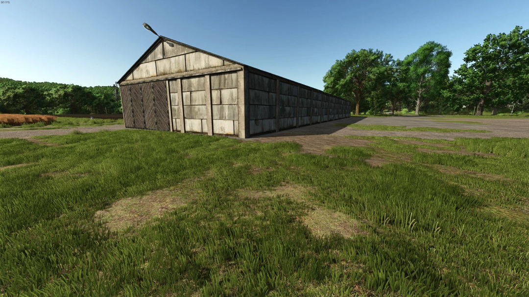 FS25 mod Grain Warehouse v1.0.0.0 showing a rustic storage building in a grassy environment.