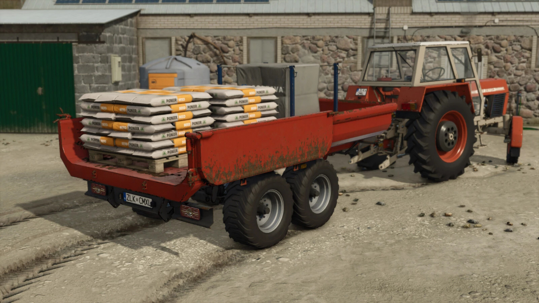 RCM PK1 v1.0.0.0 mod in FS25 showing a red trailer loaded with seed bags hitched to a tractor.