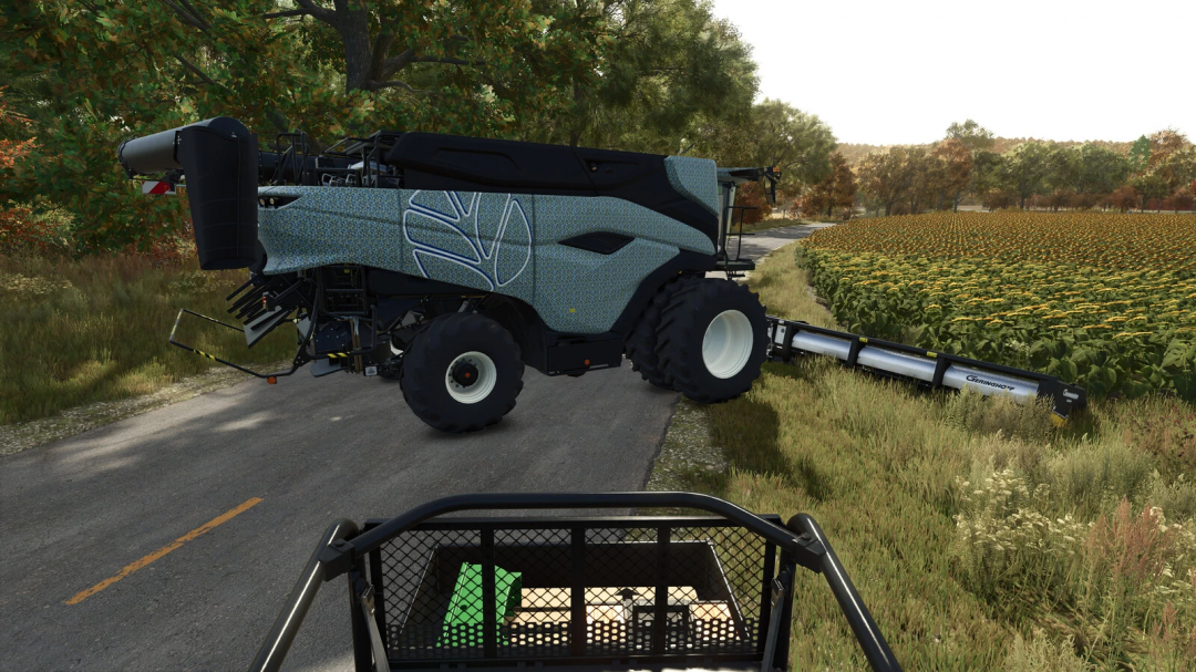 FS25 mods: Modern combine harvester on a countryside road beside a sunflower field in Farming Simulator 25.