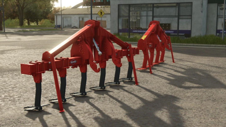 fs25-mods,  Kuhn DC pack mod for Farming Simulator 25, showing large red tillage implements placed outdoors on a commercial lot.