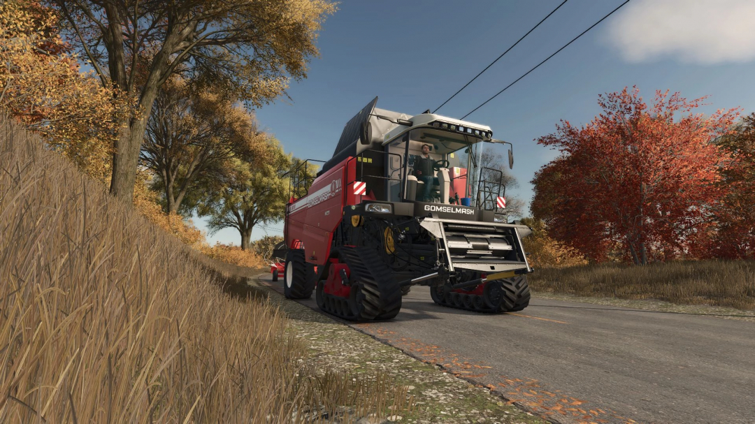 Farming Simulator 25 mod: GOMSELMASH Palesse GS3219 harvesting machine on a rural road with autumn trees