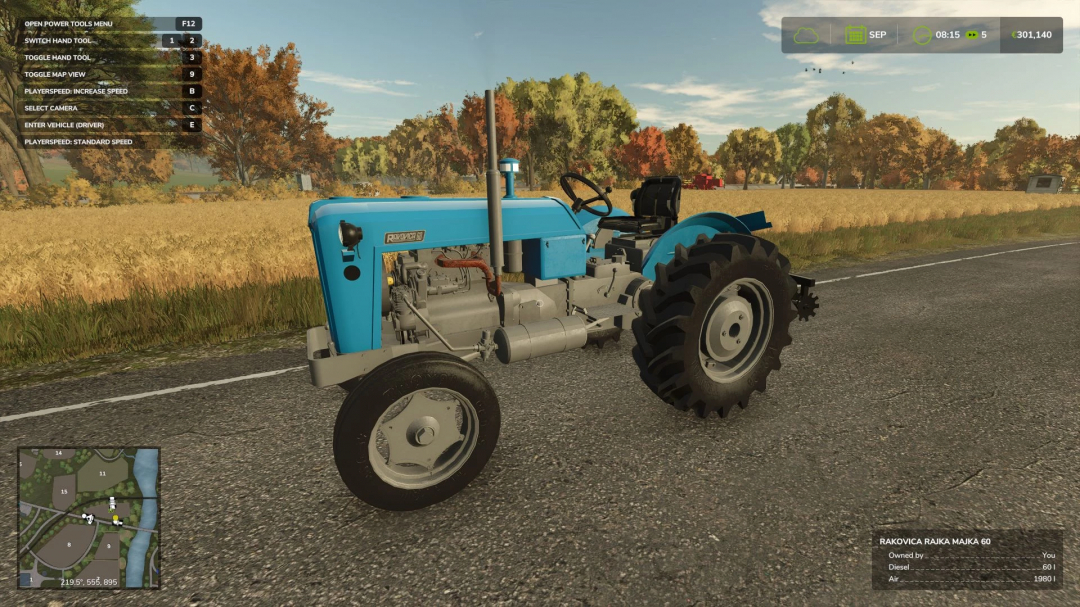Farming Simulator 25 mod: RaKovica 60 tractor on a rural road with autumn trees and a field in the background. Showcases the FS25 mod in-game.