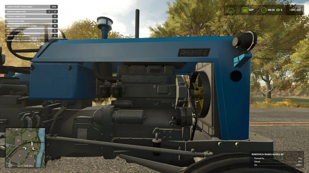 Close-up of the blue Rakovica 60 mod from Farming Simulator 25, showing detailed engine components with a background of autumn trees.