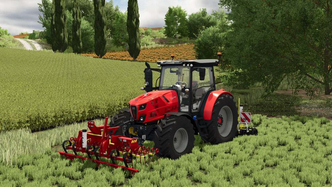 Farming Simulator 25 mod: Red tractor in a field with cultivator, lush green grass, trees, and farmland in the background.