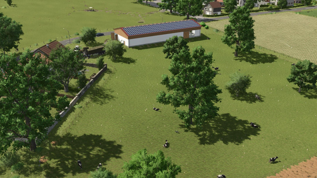 A lush pasture with cows grazing next to a building with solar panels, part of Farming Simulator 25 mods, Bavarian Cowshed v1.0.0.1.