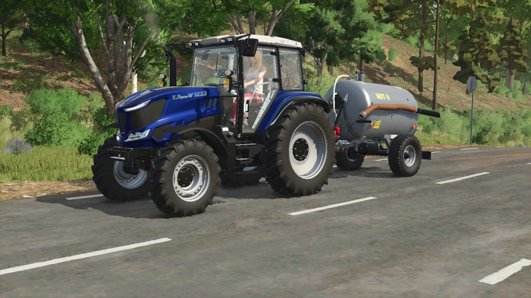 Farming Simulator 25 mod: Blue tractor with tank attachment on Rural road, used for agricultural tasks in FS25.