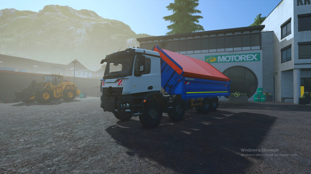 Farming Simulator 25 mod featuring a Mercedes Arocs 8x8 truck with a colorful tipper trailer, parked outside a Motorex building in FS25.