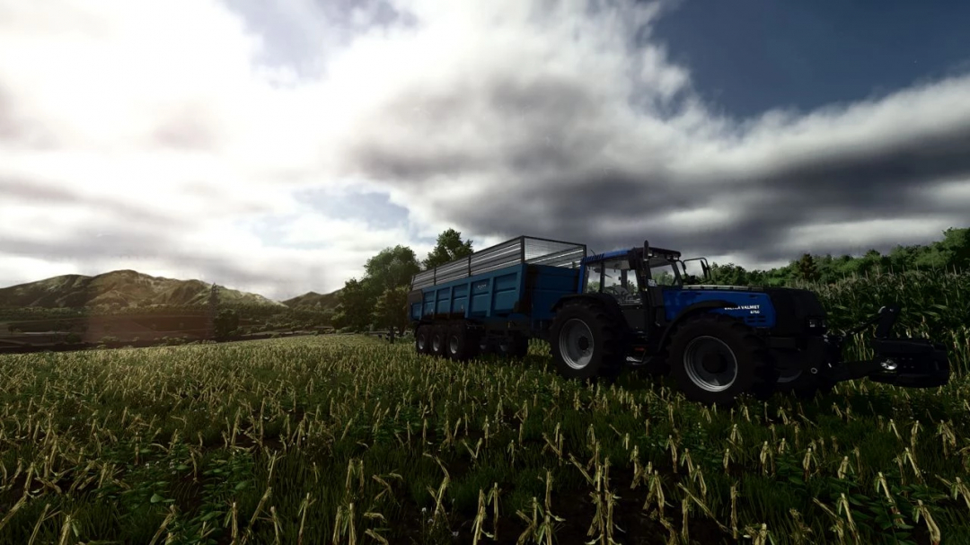 Farming Simulator 25 mod featuring a Valmet tractor with a blue cargo trailer, set in a lush field under cloudy skies.