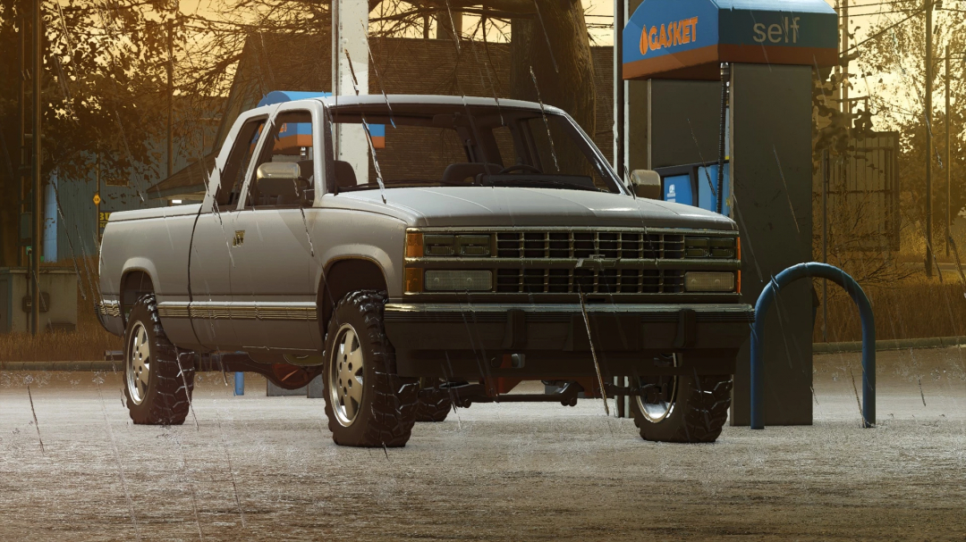 In-game image of a lifted Chevy K/1500 pickup truck from FS25 mods at a gas station in Farming Simulator 25, during rainy weather.