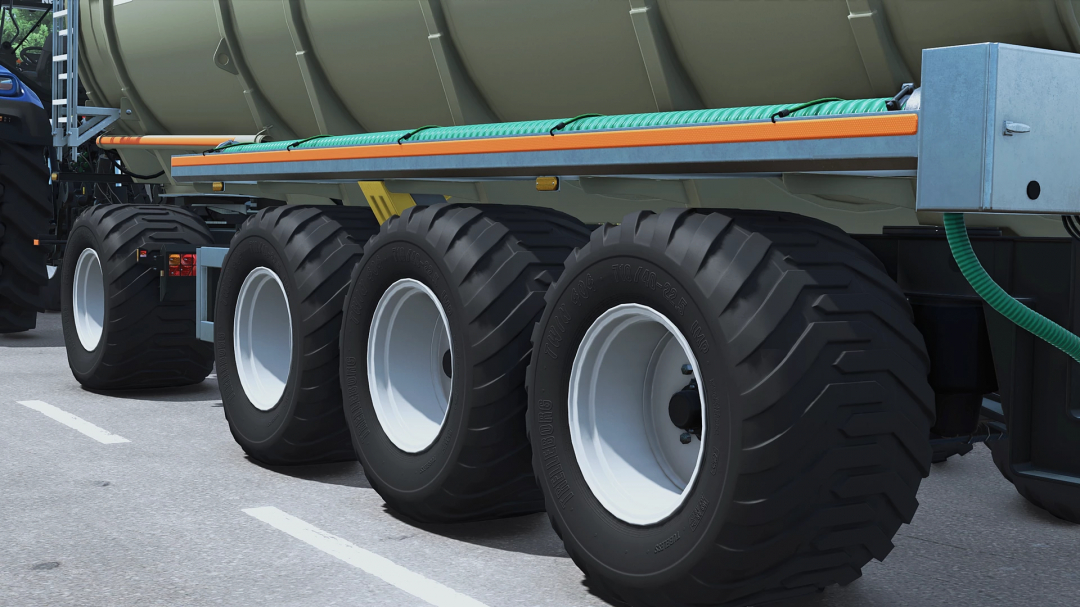 Close-up of large tractor tires and a part of a farming trailer with hoses, in Farming Simulator 25 with FS25 mods.