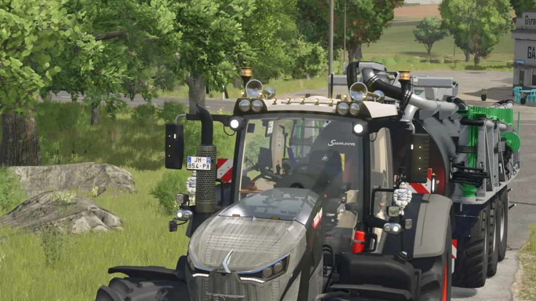 Farming Simulator 25 mod featuring a detailed Fendt 900 Vario tractor with equipment, parked beside a grassy area with trees.