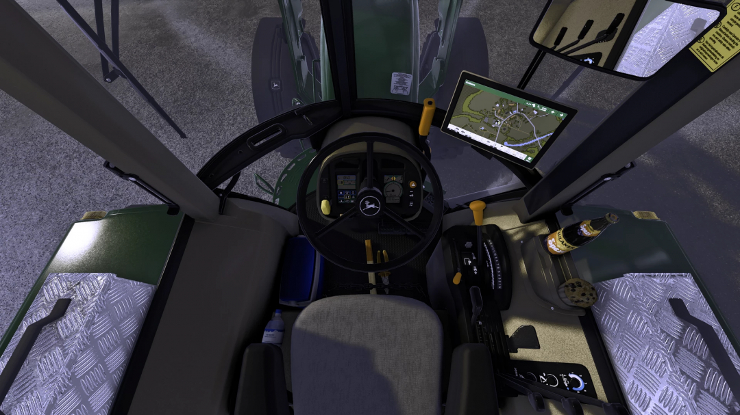 Inside view of a John Deere tractor in Farming Simulator 25 with a mounted GPS display and steering wheel, part of the FS25 mods.