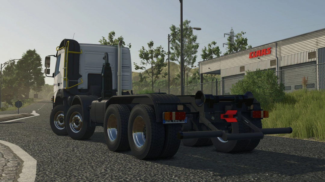 Farming Simulator 25 mod: Volvo FMX Ampiroll 8x4 truck on the road near a CLAAS building, showcasing the FS25 mods.