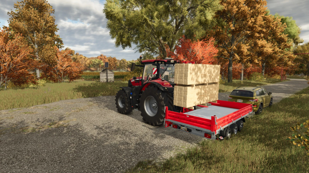 Farming Simulator 25 mod: Red tractor with a front loader carrying large bales, parked on a rural road amidst autumn trees.