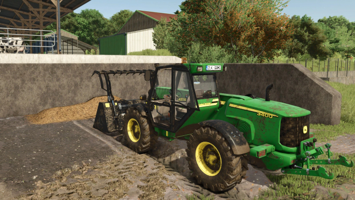 fs25-mods, Farming Simulator 25 mod featuring a green John Deere 3400 tractor with attachments, parked near a barn with hay and farmyard background.