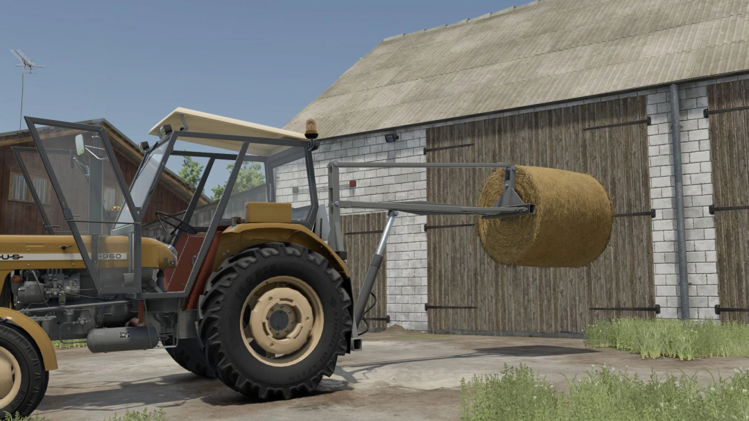 Farming Simulator 25 mod: tractor with back lifter holding a hay bale, located near a barn with wooden doors.