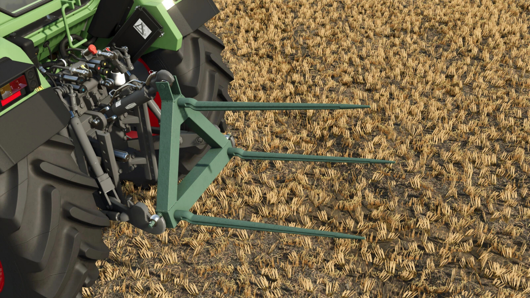 Close-up of a bale pitchfork pack mod in Farming Simulator 25, attached to a tractor, in a harvested field.