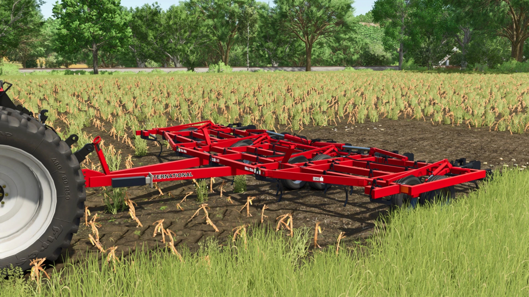 Farming Simulator 25 mod: Red FS25 CaseIH 4600 Vibra Shank cultivator in a field with crops and trees in the background.