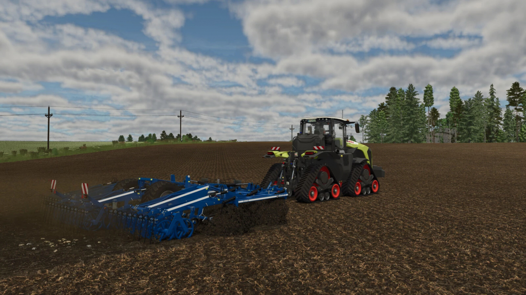 Farming Simulator 25 mod: a large tracked tractor with a blue tillage implement working on a field under a partly cloudy sky.
