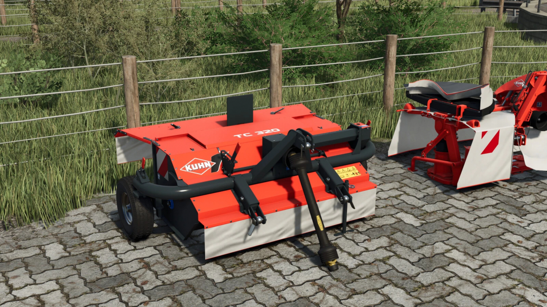 Farming Simulator 25 mods: Kuhn TC 320 mower attachment on a cobblestone surface, with grassy background and wooden fence.