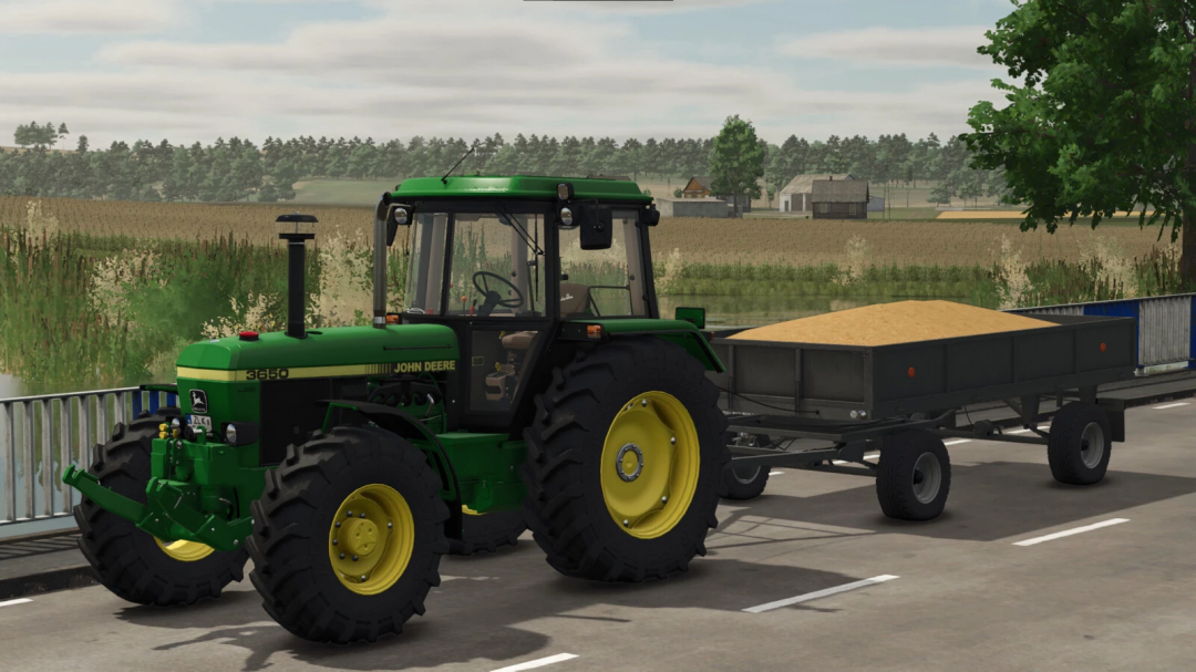 Farming Simulator 25 mods: John Deere 3650 tractor with a trailer loaded with sand, parked on a farm road.