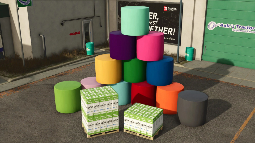 Colorful cylindrical objects and boxes of Lizard GecoWrap mod in Farming Simulator 25, displayed outdoors near buildings and signs.