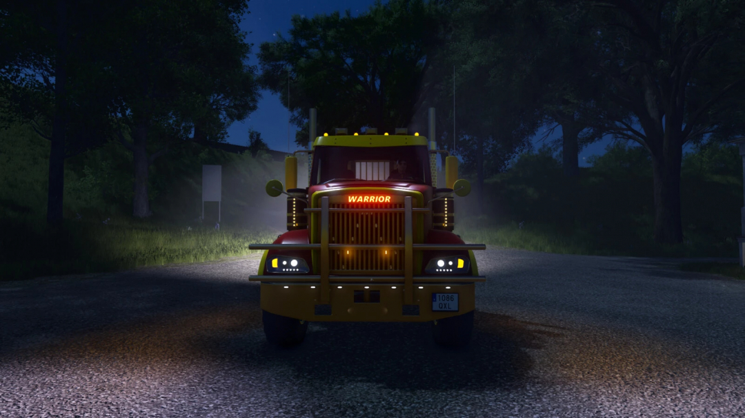 Nighttime image of a red and yellow Warrior truck with bright headlights, part of Farming Simulator 25 mods, parked on a gravel road.