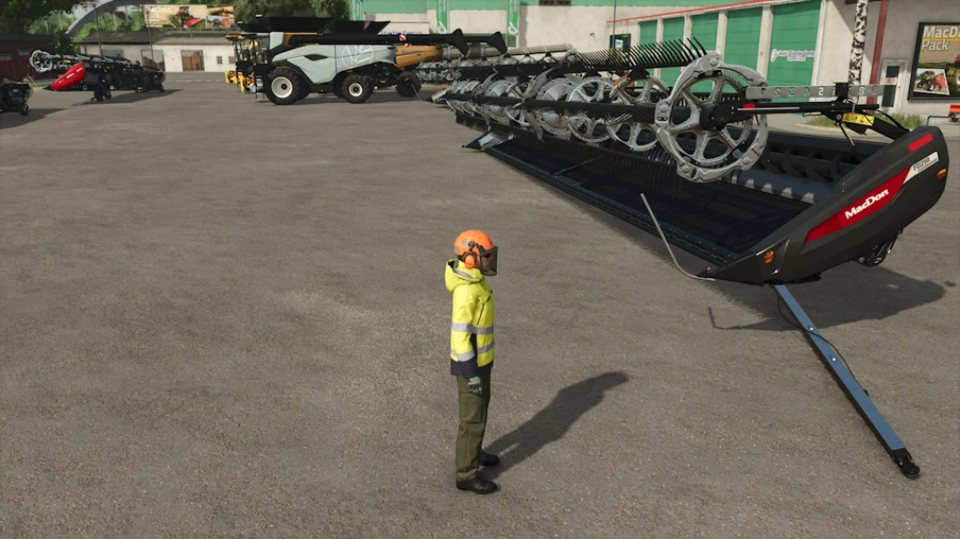 Farmer in safety gear standing near a large MacDon harvesting header for farming simulator 25 mods.