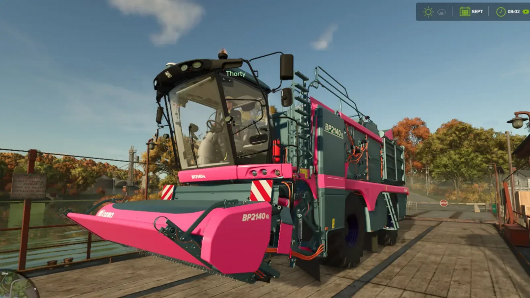 Farming Simulator 25 mod featuring the Oxbo Pack BP2140e harvester, colorful pink and grey design, on a farm dock with autumn trees.