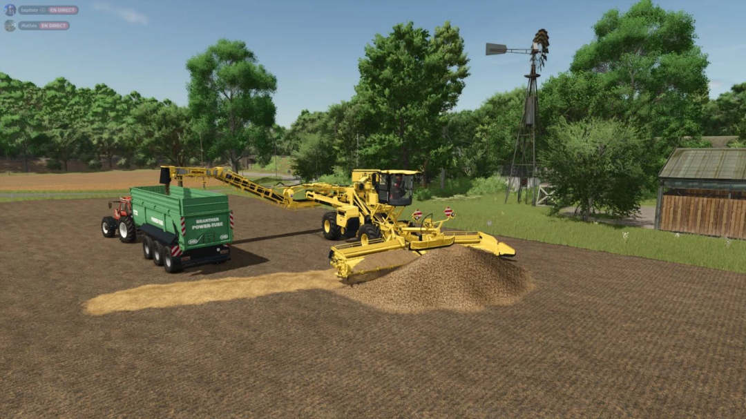 Farming Simulator 25 mod image showing a yellow Ropa Maus 5 soil cultivator working on a field with a green trailer attached, surrounded by trees and farm buildings.