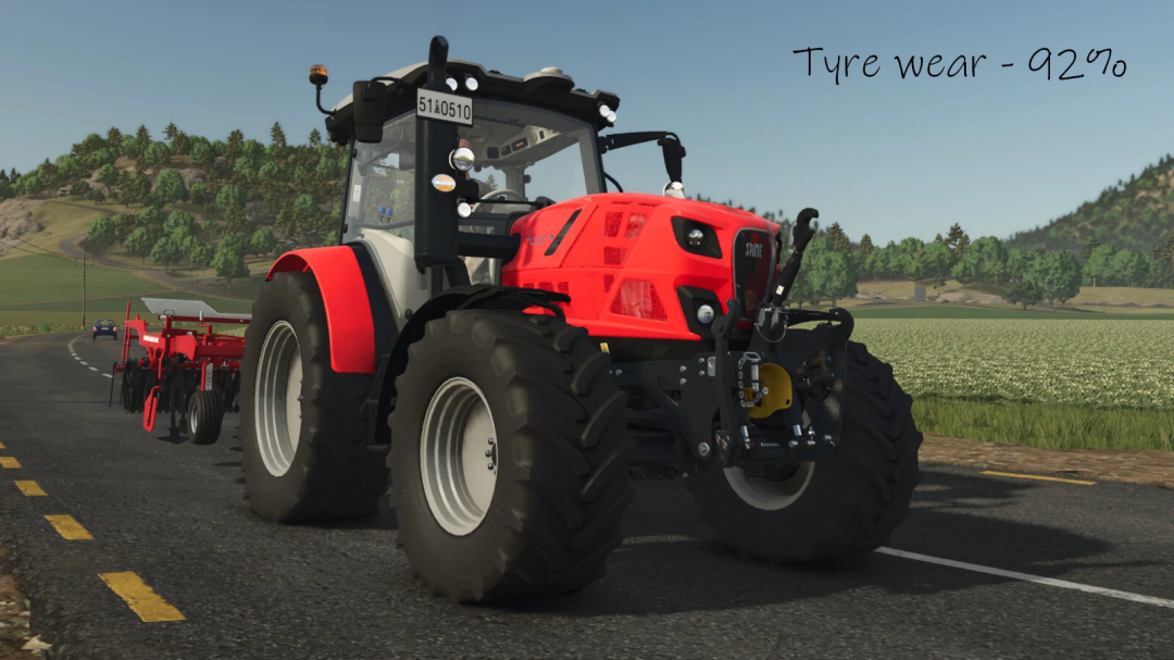 Farming Simulator 25 mod tractor with 92% tyre wear, used in FS25 mods for agriculture. Front view of a red tractor on a rural road.