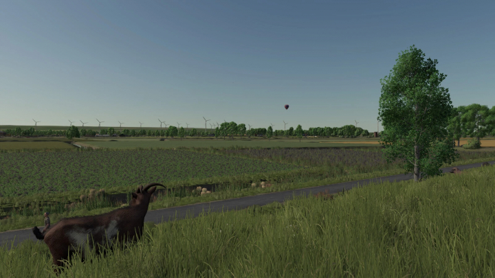 fs25-mods, Farming Simulator 25 mod scene with wind turbines, trees, a person, a goat, and a hot air balloon in a rural landscape.