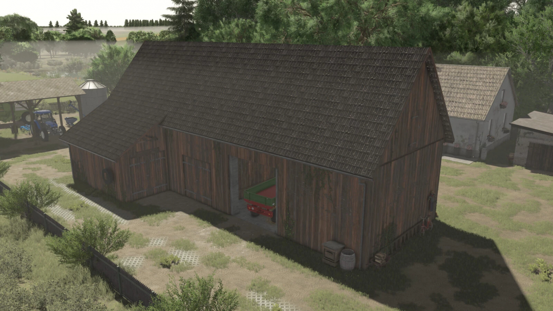 Barn with a cowshed mod in Farming Simulator 25, showcasing a rustic wooden barn with a small green trailer, surrounded by farm buildings and greenery.