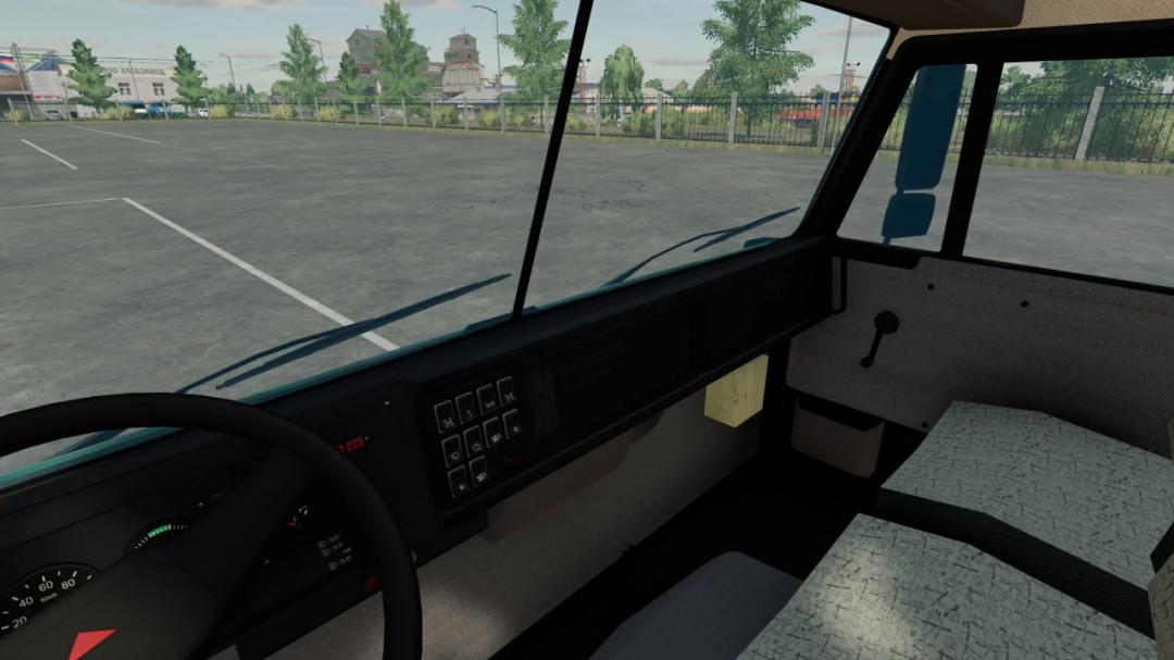 Inside view of a KamAZ 65115 truck from FS22, showing the dashboard, steering wheel, and passenger seat in a parking lot scene.