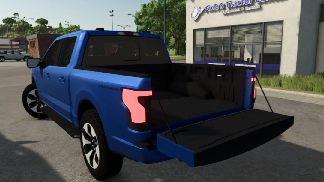 Blue Ford F-150 Lightning pickup truck mod from Farming Simulator 25 with open tailgate, parked outside a tractor equipment store.