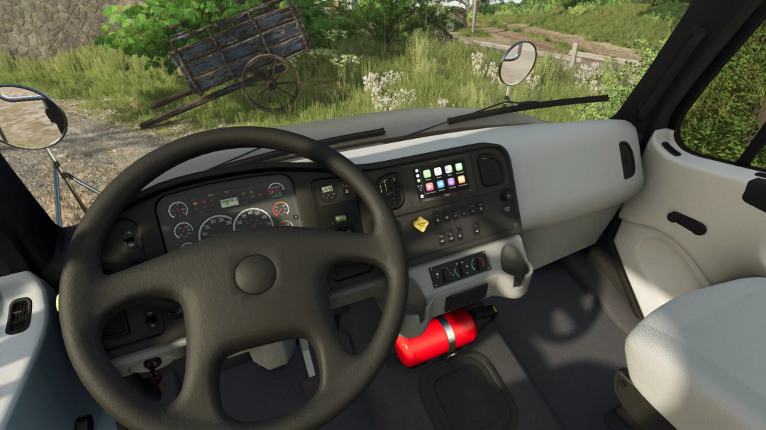 Inside view of a Freightliner M2 Stakebed truck in Farming Simulator 25, showing the dashboard, steering wheel, and outside scenery.