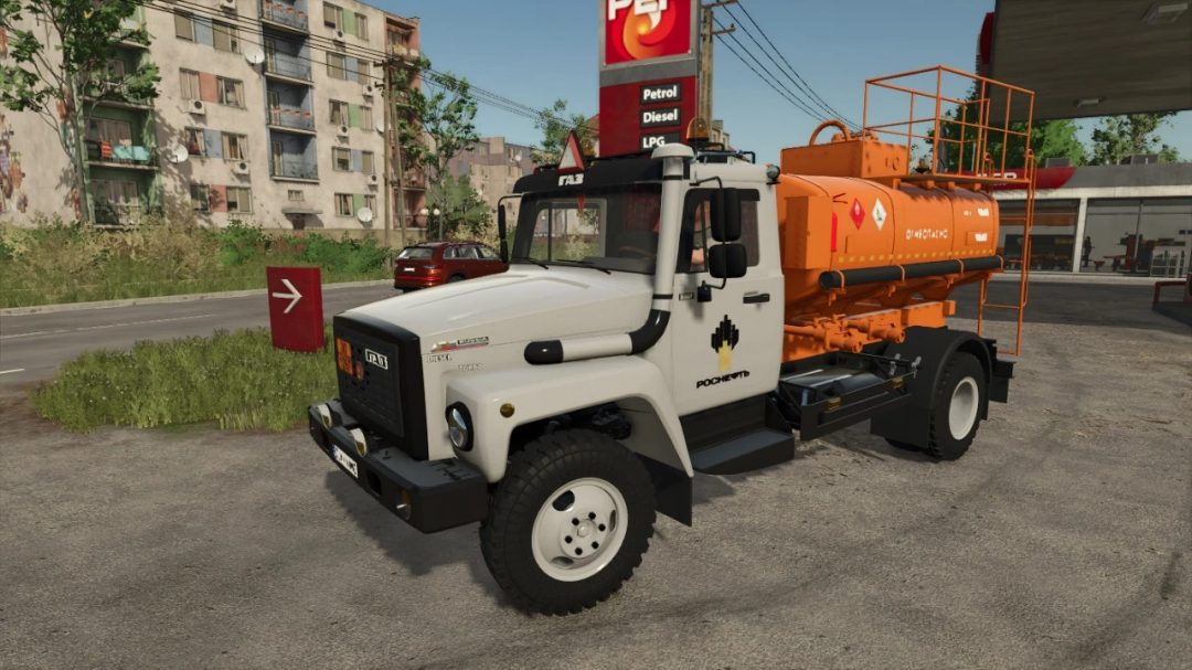 Farming Simulator 25 mod: GAZ-3307 water tanker with orange tank and safety hazard symbols, parked near a fuel station in an urban environment.