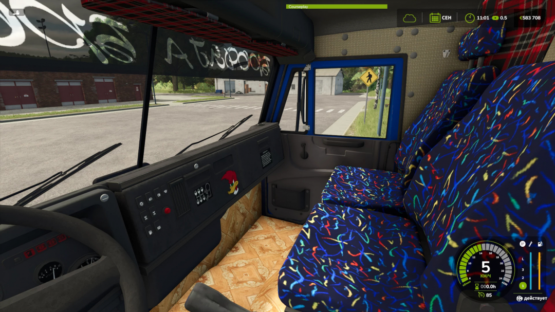 Inside the cabin of a KamAZ 53212 from FS25 mods in Farming Simulator 25 with colorful patterned seats and dashboard.