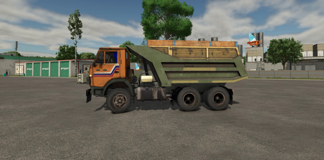 Farming Simulator 25 mod featuring a vintage KamAZ 5511 truck with a green dump bed, in an industrial parking lot setting.