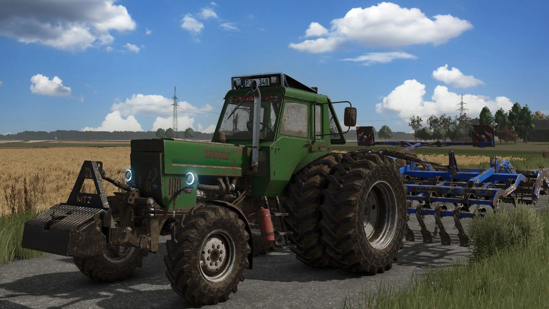 Farming Simulator 25 mod featuring a green MTZ 82 Turbo tractor with blue cultivator attachment on a farm field.