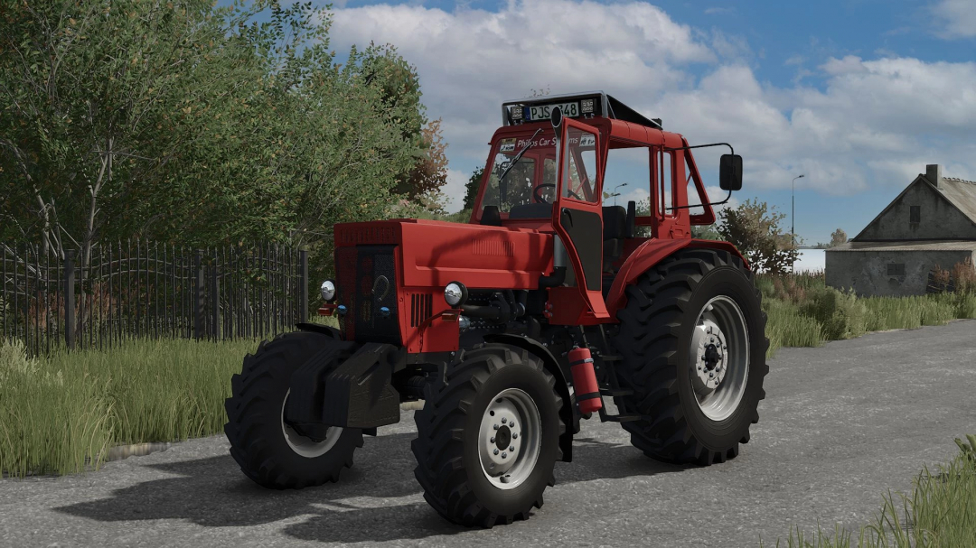 Red tractor from FS25 mods in Farming Simulator 25, parked on a gravel road with trees and a house in the background.