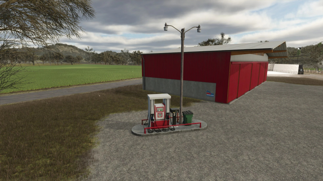 Placeable gas station mod in Farming Simulator 25, located near a red storage shed with fuel pump and streetlamp, on a countryside landscape.