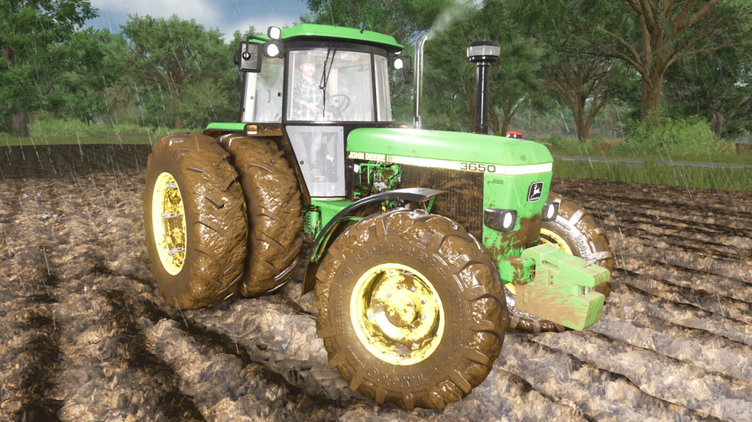 John Deere 3650 tractor with muddy tires in a rainy field, from Farming Simulator 25, featuring the Real Dirt Color mod.