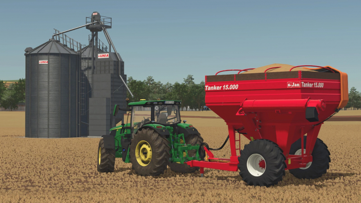 fs25-mods,  Farming Simulator 25 mod: a green tractor attached to a red Jan Tanker Small Series 15,000 for grain transport, near silos in a farm field.