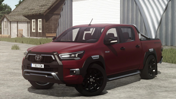 fs25-mods, Farming Simulator 25 mod: Toyota Hilux Invincible 2021 in red with black accents, parked outdoors with farm buildings in the background.